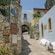 A Greek neighborhood featuring arches, rustic architecture and a stone walkway with steps
